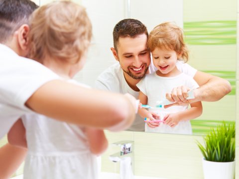 Happy Family Father And Child Girl Brushing Her Teeth