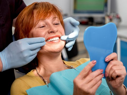 woman choosing dentures or dental implants